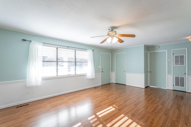 unfurnished room featuring wood-type flooring, a textured ceiling, and ceiling fan