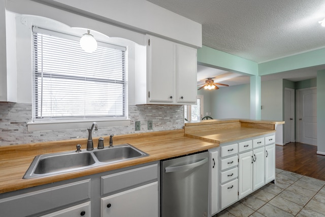 kitchen with backsplash, white cabinetry, dishwasher, and plenty of natural light