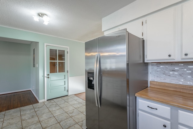 kitchen featuring white cabinets, light hardwood / wood-style floors, stainless steel fridge with ice dispenser, and tasteful backsplash