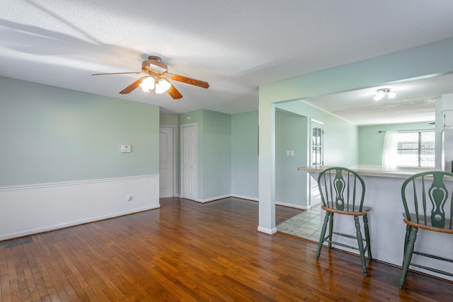 empty room featuring dark hardwood / wood-style floors, ceiling fan, and a textured ceiling