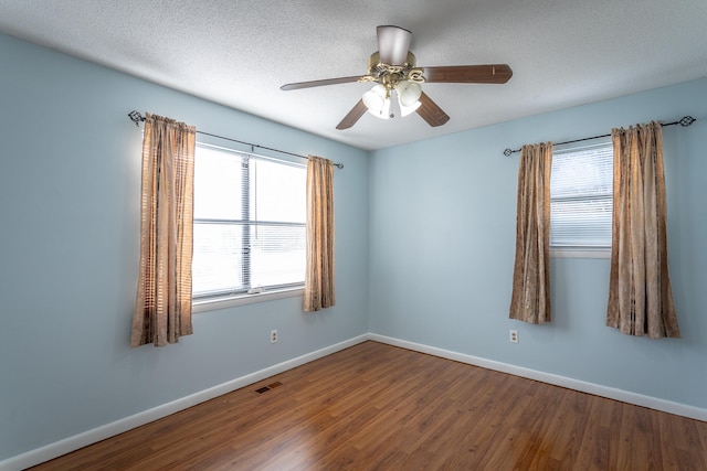 spare room with hardwood / wood-style flooring, ceiling fan, and a textured ceiling