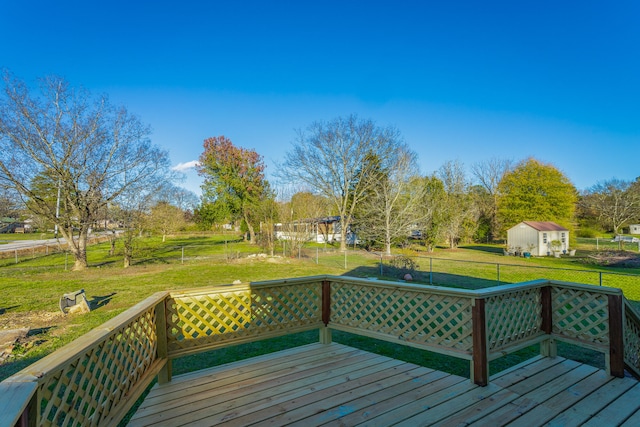 wooden deck featuring a storage shed and a lawn