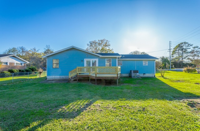 back of property with a yard, central air condition unit, and a wooden deck