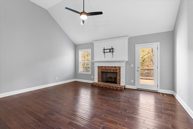 unfurnished living room featuring a healthy amount of sunlight, dark hardwood / wood-style flooring, lofted ceiling, and a fireplace