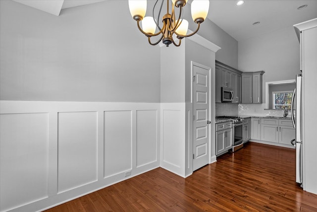 kitchen with stainless steel appliances, dark wood-type flooring, decorative light fixtures, a chandelier, and gray cabinets