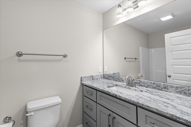 bathroom with vanity, toilet, and walk in shower