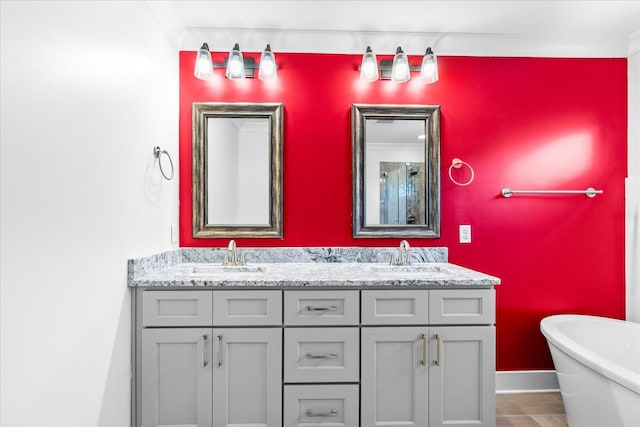 bathroom with a tub, vanity, and ornamental molding