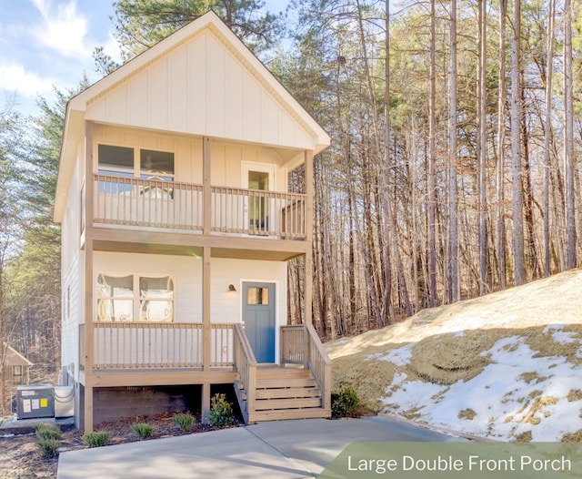 front of property featuring cooling unit, a balcony, and a porch