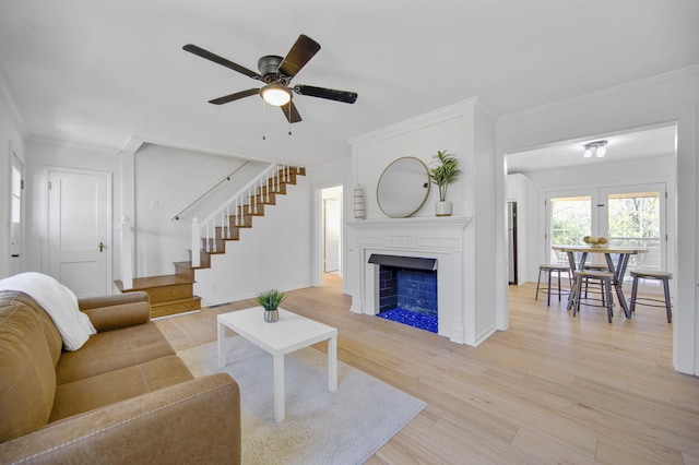 living room with light hardwood / wood-style flooring, ceiling fan, and ornamental molding