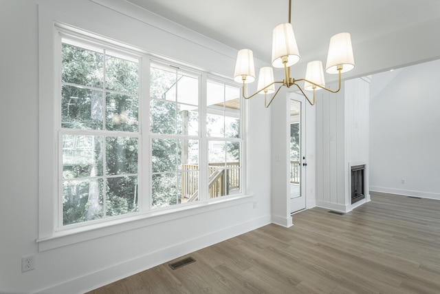 unfurnished dining area featuring hardwood / wood-style flooring and a notable chandelier