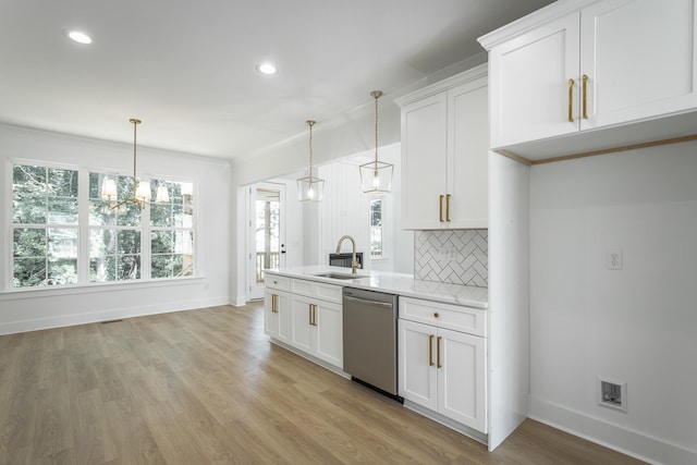 kitchen with pendant lighting, white cabinetry, sink, and stainless steel dishwasher