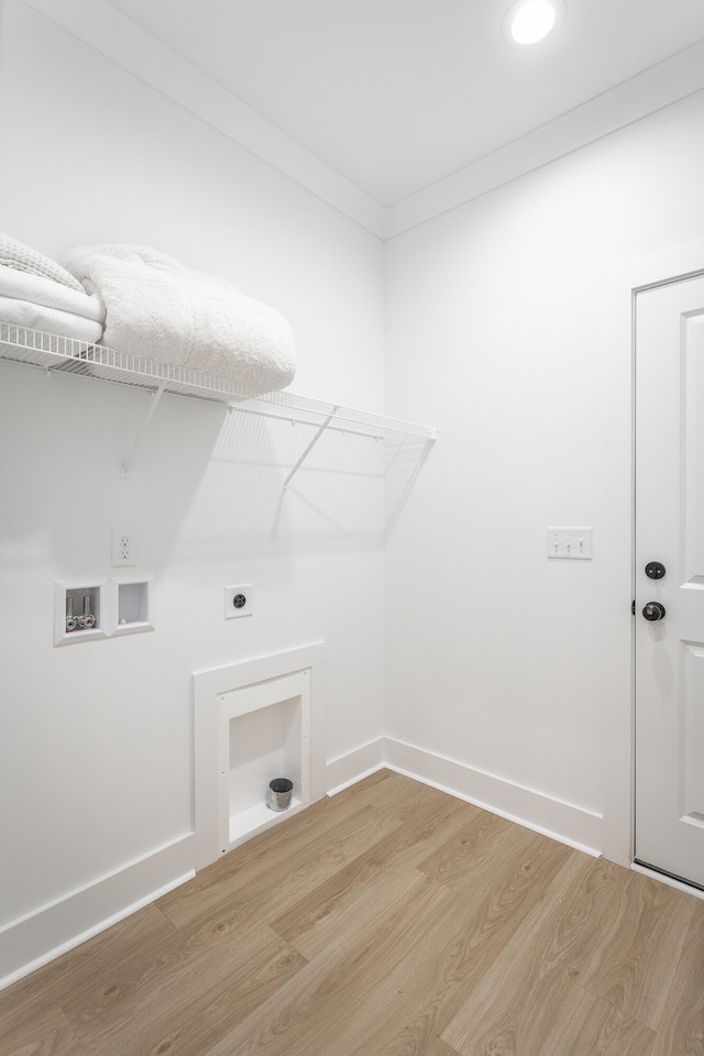 laundry area featuring hookup for an electric dryer, washer hookup, light hardwood / wood-style flooring, and crown molding