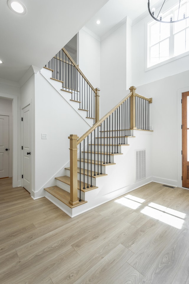 stairway featuring wood-type flooring and ornamental molding