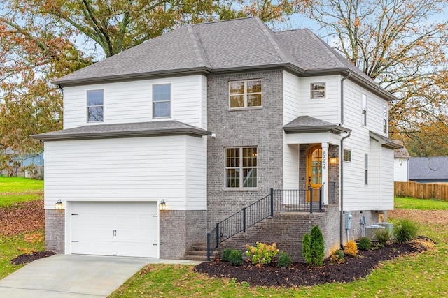 view of front of property with a garage and central AC