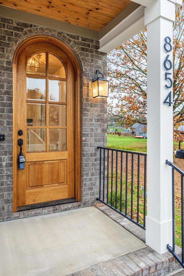 view of exterior entry featuring covered porch