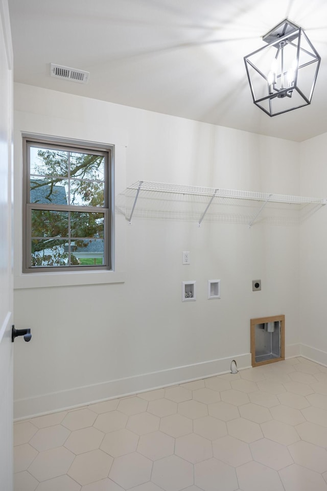 laundry area featuring electric dryer hookup, hookup for a washing machine, light tile patterned floors, and an inviting chandelier