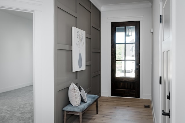 doorway to outside featuring light hardwood / wood-style floors and crown molding