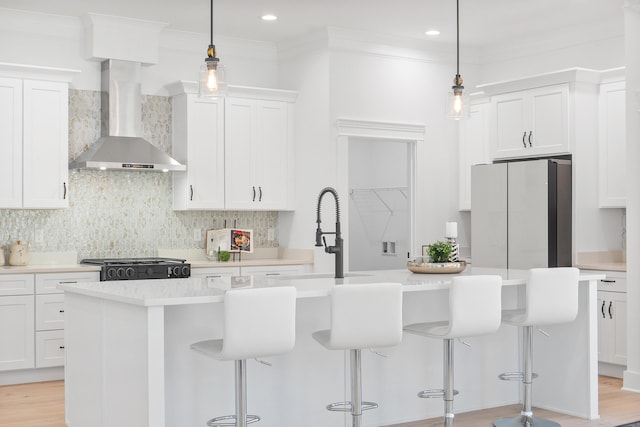 8340 Snowdrop Way, Ooltewah, TN 37363 - kitchen featuring wall chimney exhaust hood, freestanding refrigerator, backsplash, white cabinetry, and crown molding