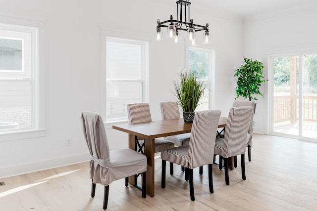 dining room with light hardwood / wood-style floors and ornamental molding