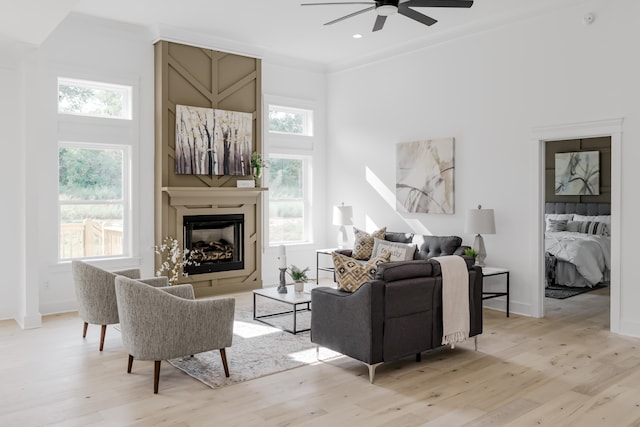 living room with ceiling fan, light hardwood / wood-style flooring, and crown molding