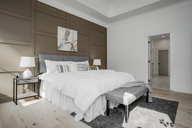 bedroom with crown molding and light wood-type flooring