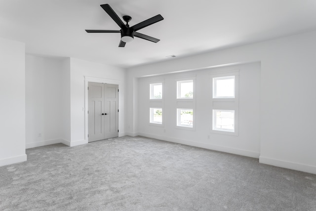 interior space with ceiling fan and light carpet