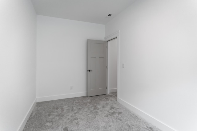 unfurnished room featuring light carpet