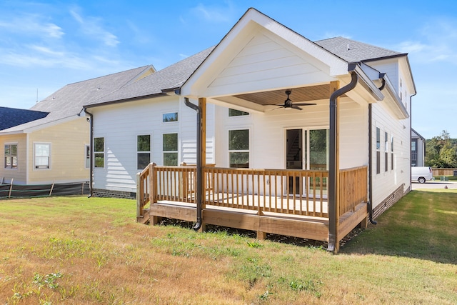 back of house featuring ceiling fan, a deck, and a yard