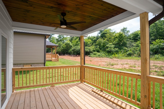 wooden deck featuring ceiling fan and a yard