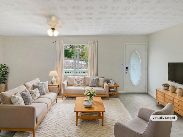 carpeted living room featuring a textured ceiling and ceiling fan