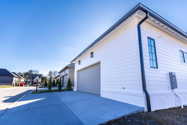 view of home's exterior with a residential view and concrete driveway