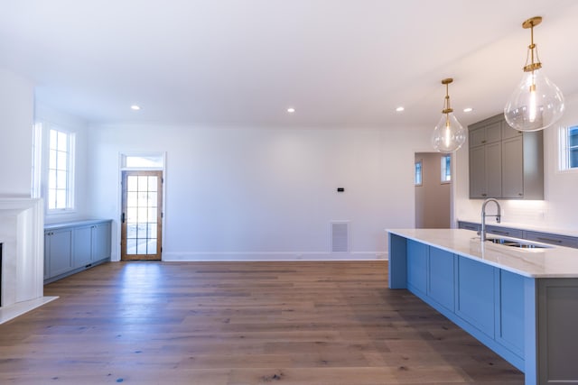 kitchen with visible vents, a sink, gray cabinetry, and wood finished floors