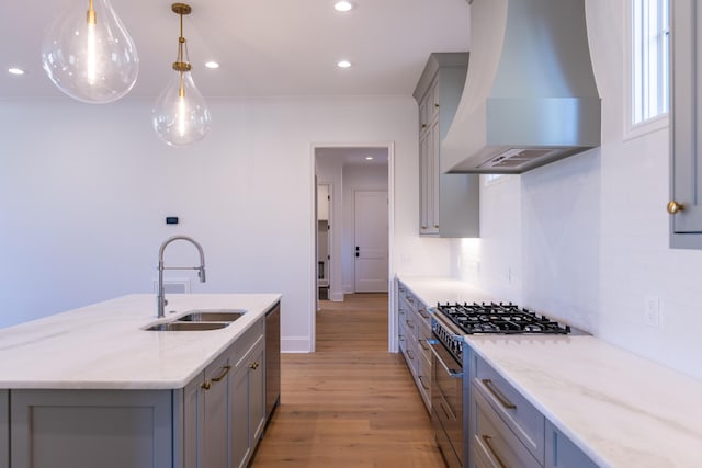 kitchen with stainless steel appliances, gray cabinets, a sink, and custom exhaust hood