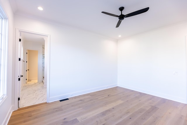 unfurnished room featuring ornamental molding, light wood-type flooring, and baseboards