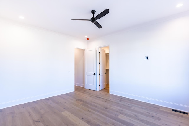 unfurnished room with crown molding, baseboards, and wood finished floors