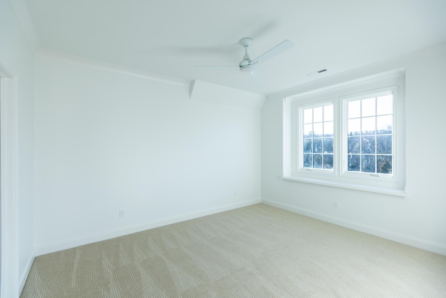 empty room with light carpet, ceiling fan, visible vents, and baseboards