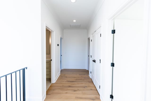 hallway featuring light wood-type flooring, baseboards, and recessed lighting