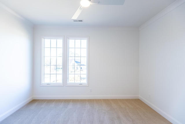 empty room featuring baseboards, a ceiling fan, visible vents, and light colored carpet