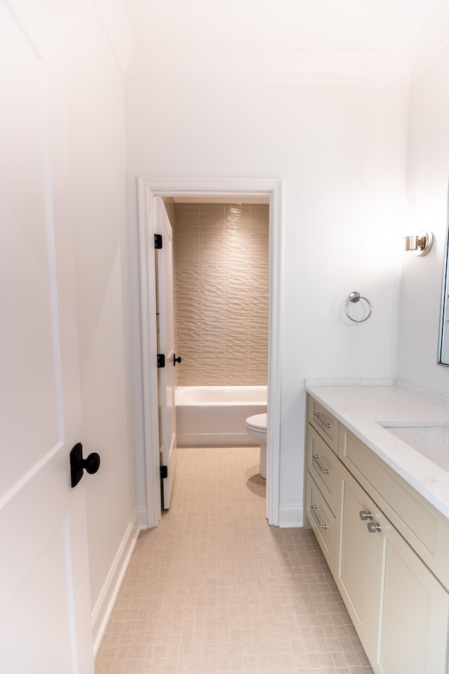 bathroom featuring toilet, vanity, and baseboards