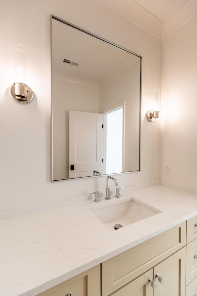 bathroom with visible vents, vanity, and crown molding