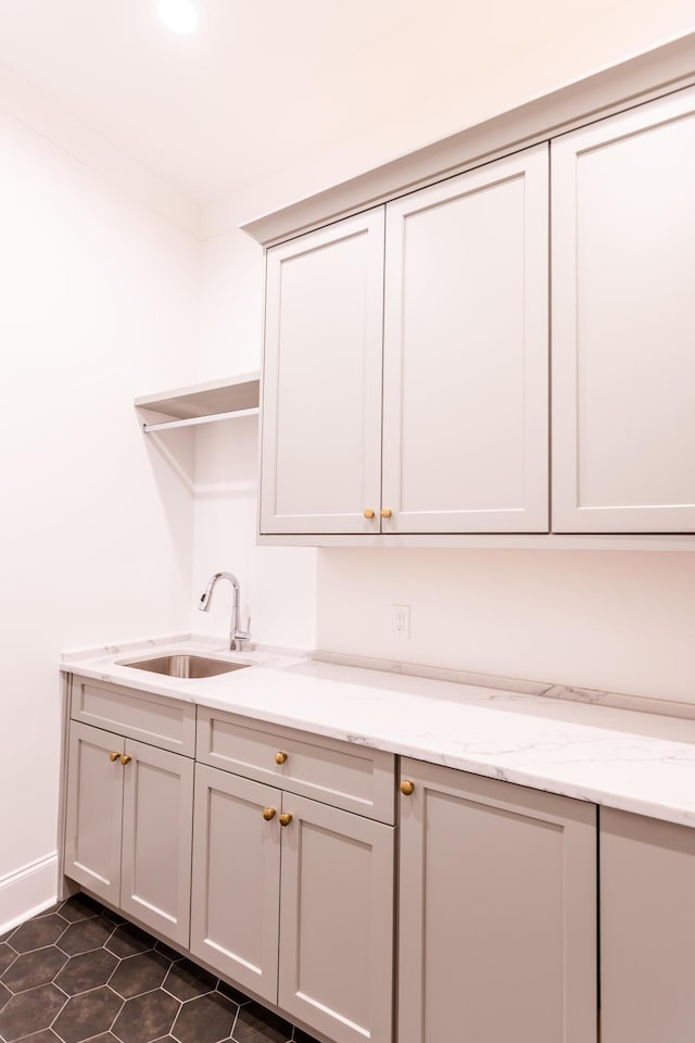 interior space featuring dark tile patterned flooring and a sink