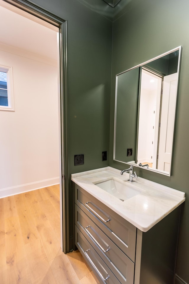 bathroom featuring wood finished floors, vanity, and baseboards