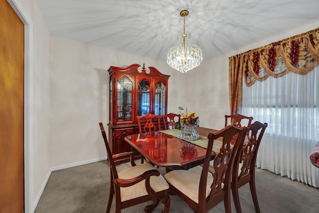 dining area featuring dark colored carpet and a notable chandelier