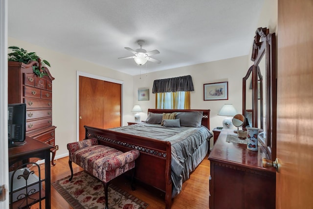 bedroom with ceiling fan, a closet, a textured ceiling, and light hardwood / wood-style flooring