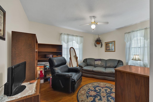 living room with ceiling fan, plenty of natural light, and wood-type flooring