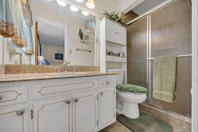 bathroom with tile patterned flooring, vanity, toilet, and a shower with door