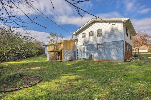 rear view of house with a lawn and a wooden deck