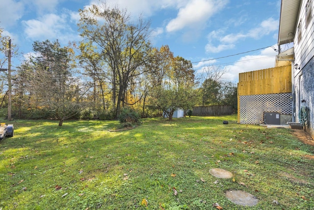 view of yard with a storage shed and central air condition unit