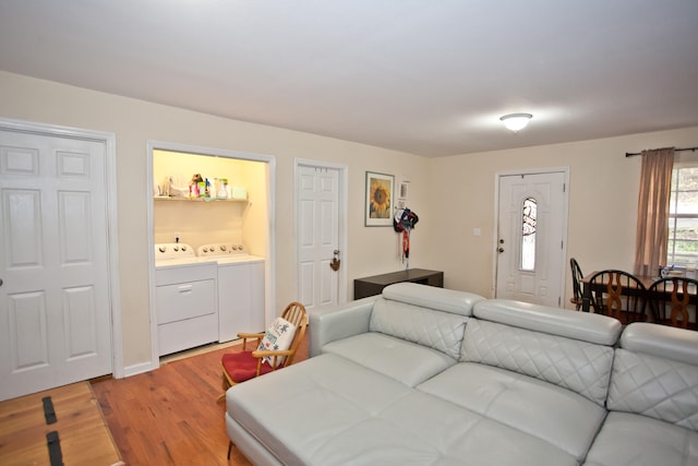 living room with washing machine and dryer and hardwood / wood-style flooring