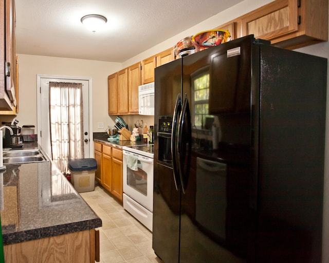 kitchen with a textured ceiling, white appliances, and sink